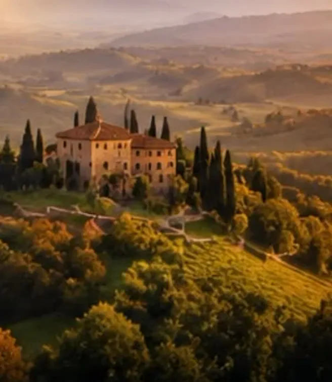 Villa toscana sulla cima di una collina tra cipressi, boschi e vigneti, al tramonto